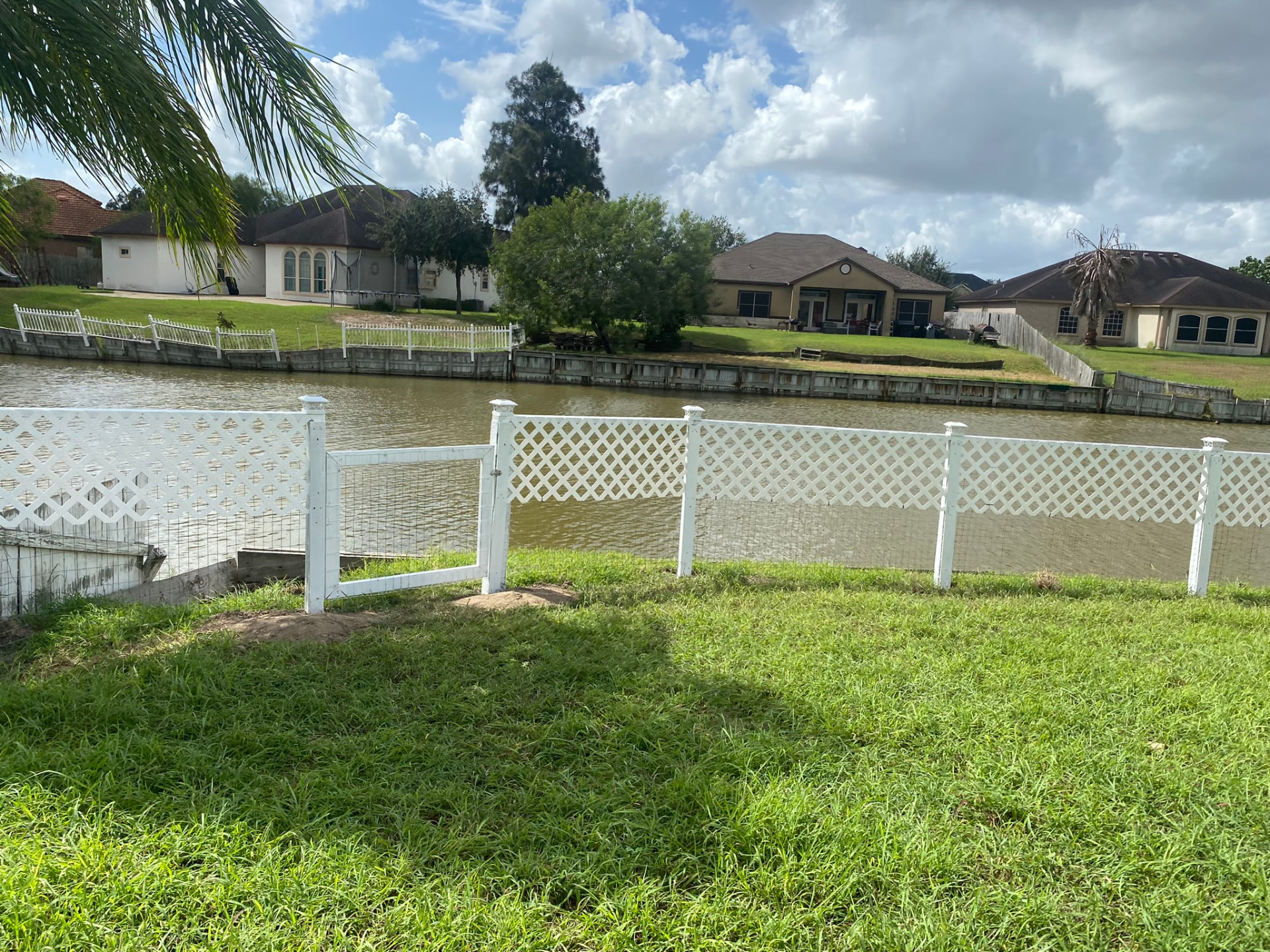 White lattice waterfront fence with gate — Rancho Viejo, TX